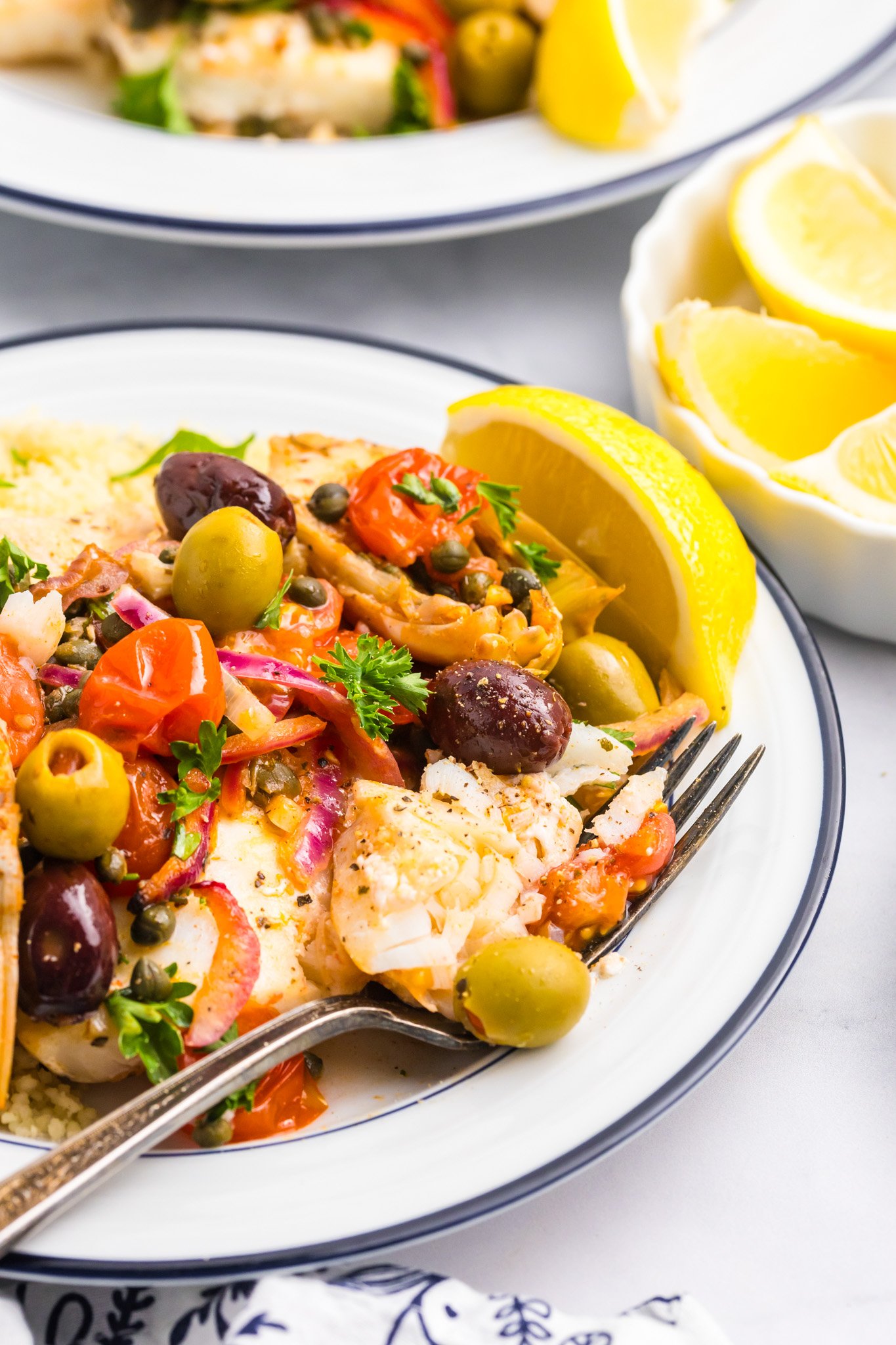 Mediterranean Baked Fish on a white plate with fork