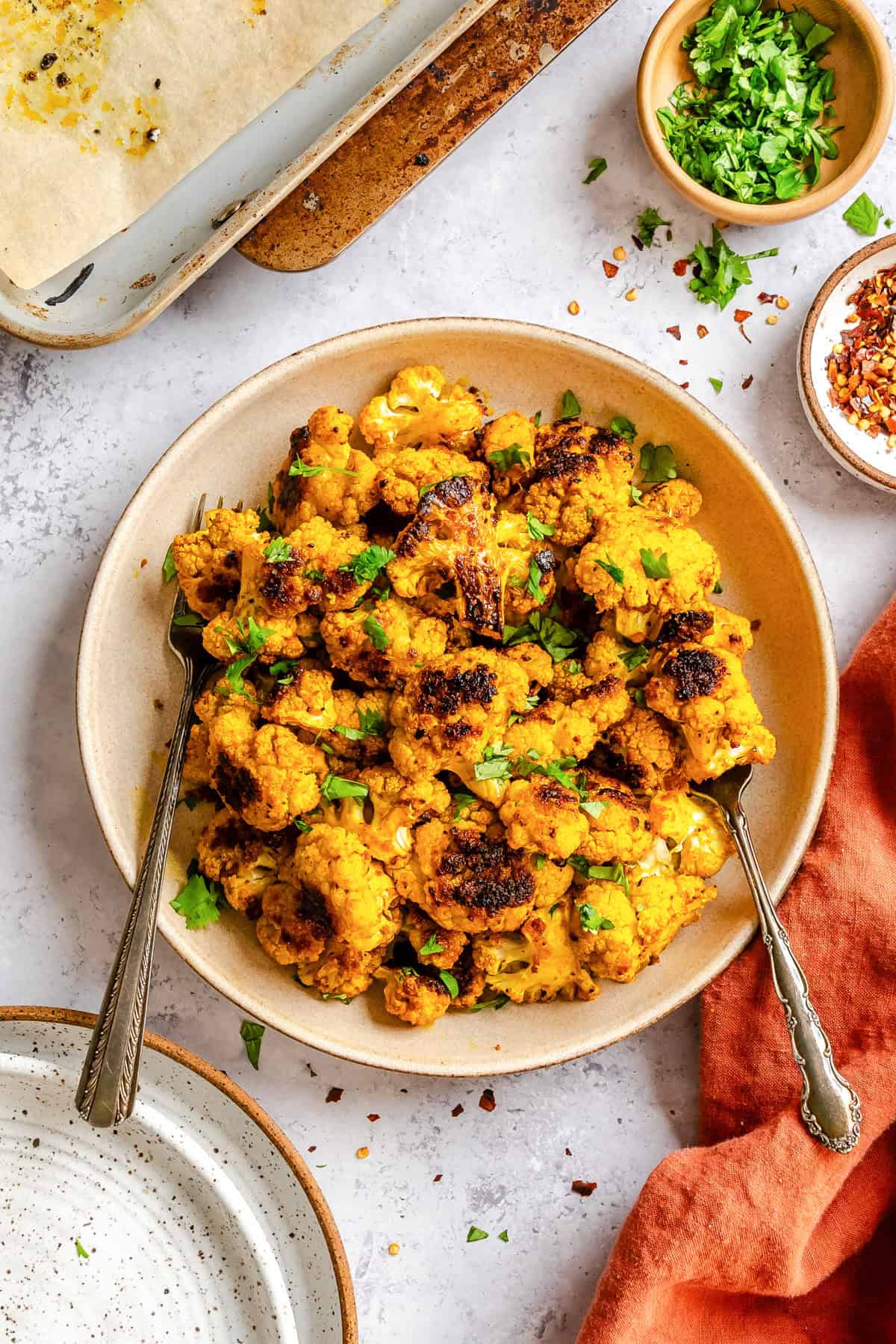 Crispy turmeric roasted cauliflower florets with golden edges on a white plate