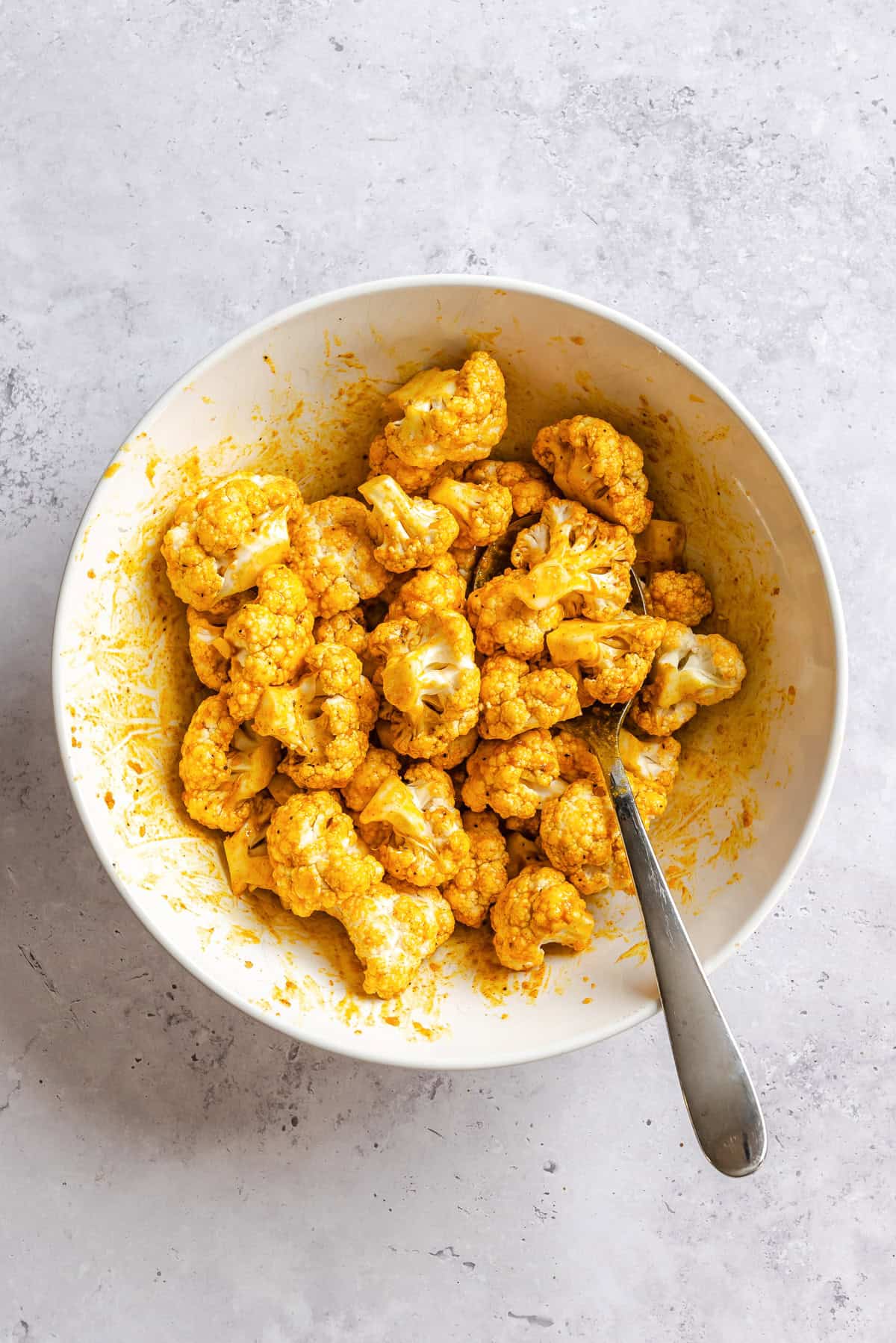 Cauliflower with spices in  a bowl with a spoon 