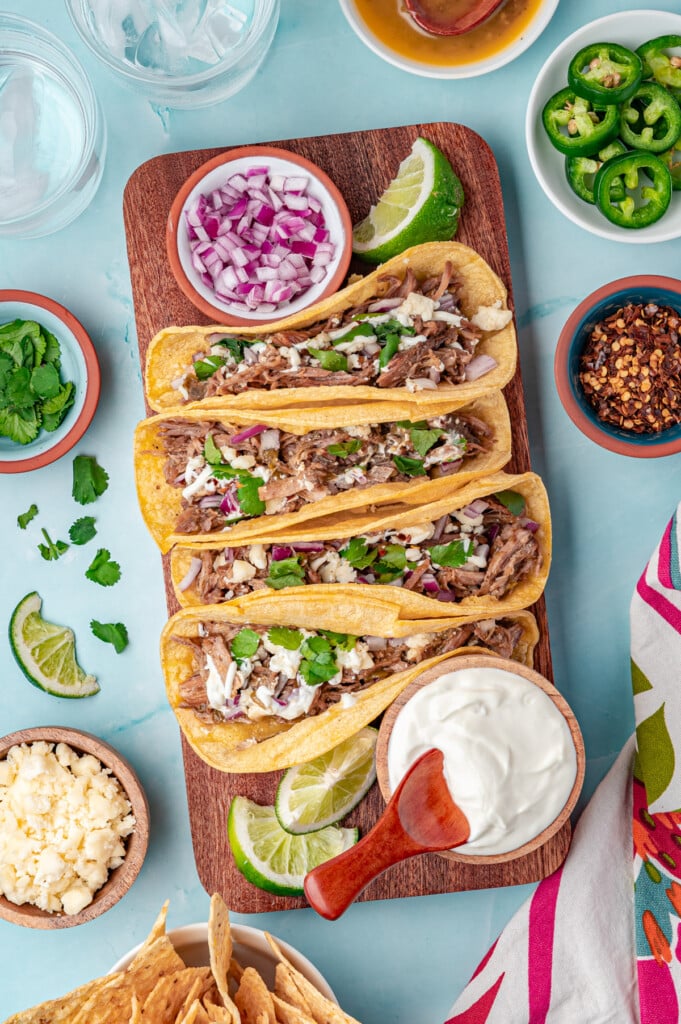 Slow Cooker Pulled Pork Tacos three tacos on a board 
