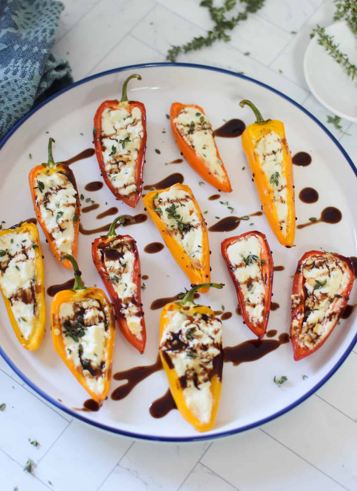 Goat Cheese Stuffed Mini Peppers on a white plate with a balsamic glaze
