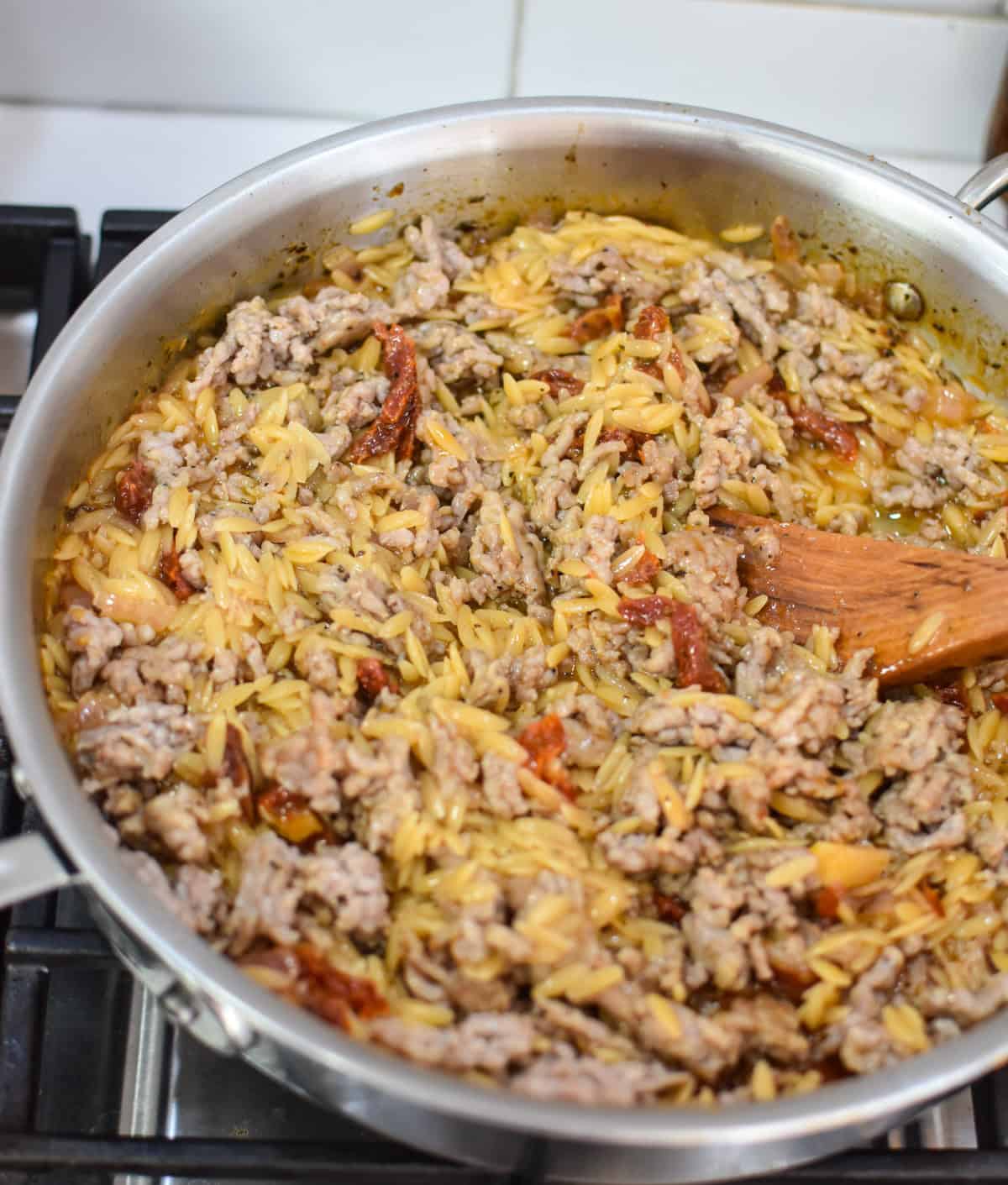 one pot sausage and orzo recipe sausage being cooked in a skillet