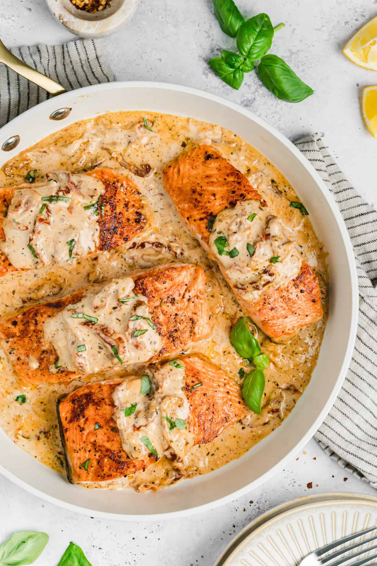 Creamy Tuscan Marry Me Salmon in a white skillet