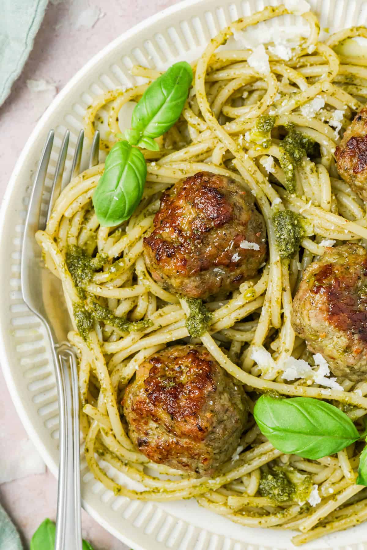 Turkey Pesto Meatballs on a white plate with basil