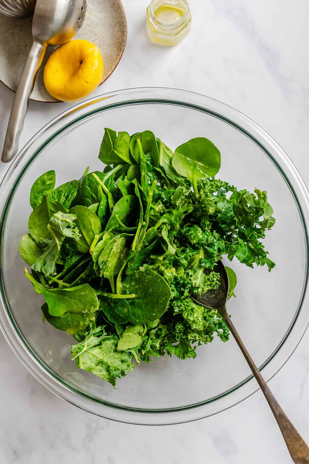Spinach and Kale Salad in a glass bowl with a spoon