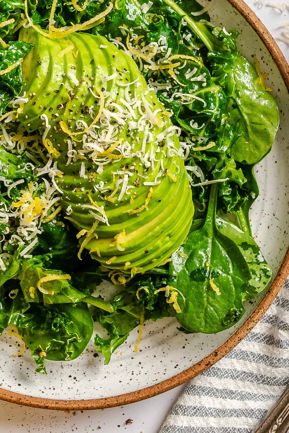 Healthy green salad with baby spinach, kale, avocado and Parmesan Cheese