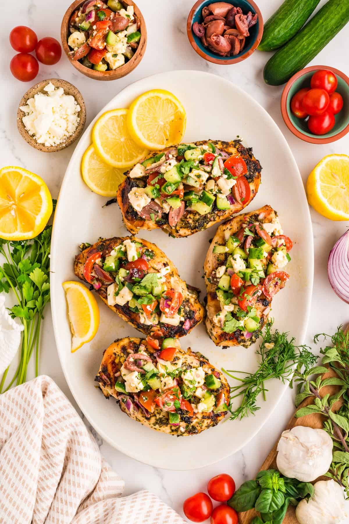 Plated grilled Mediterranean chicken breast with herb marinade drizzle and feta topping