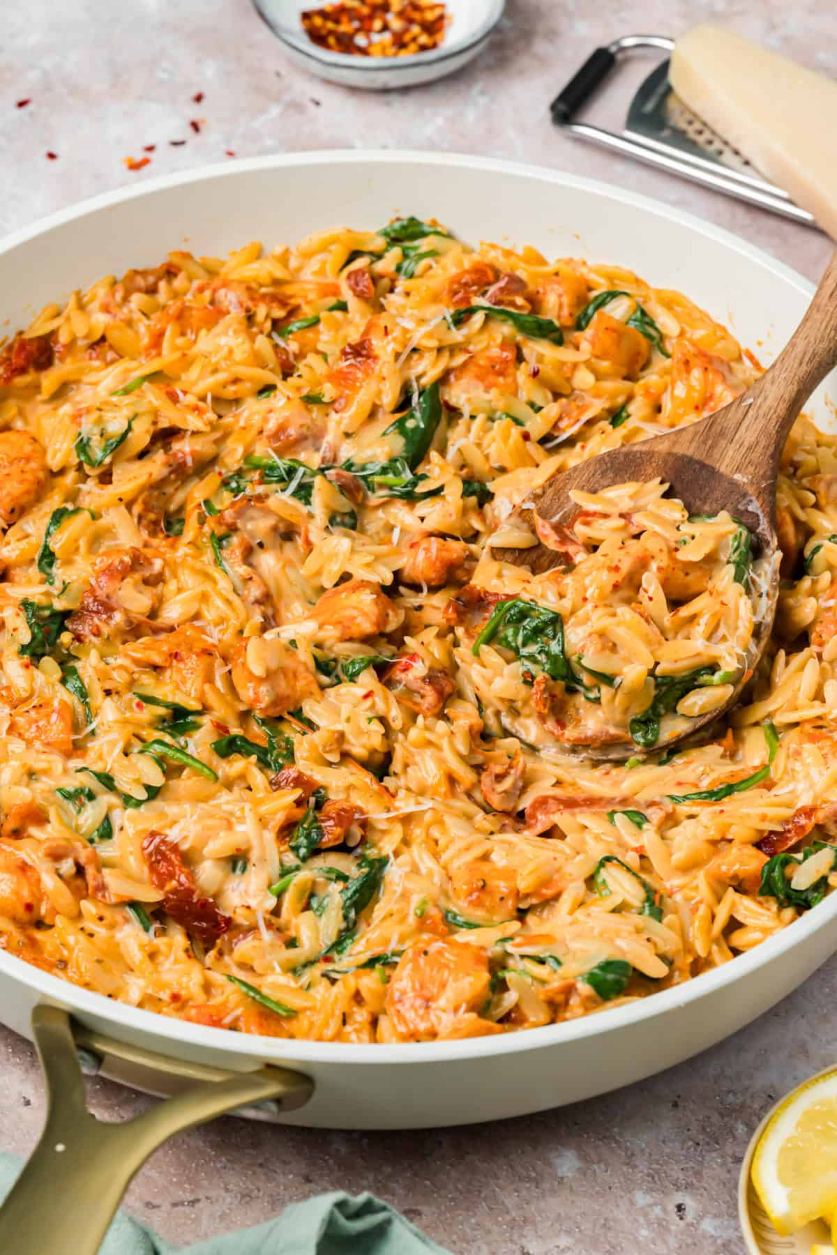 Marry me chicken orzo in a skillet with creamy Parmesan sauce, sun-dried tomatoes, and spinach