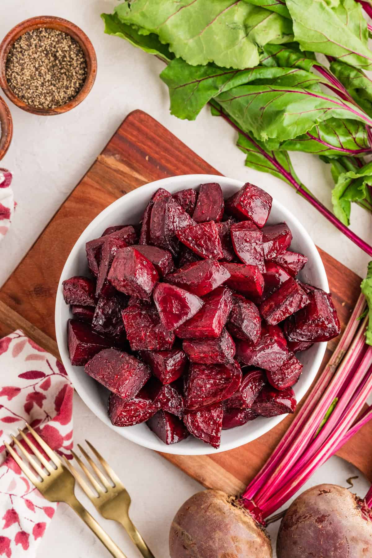 Fork tender oven roasted beets served in a shallow bowl with olive oil drizzle