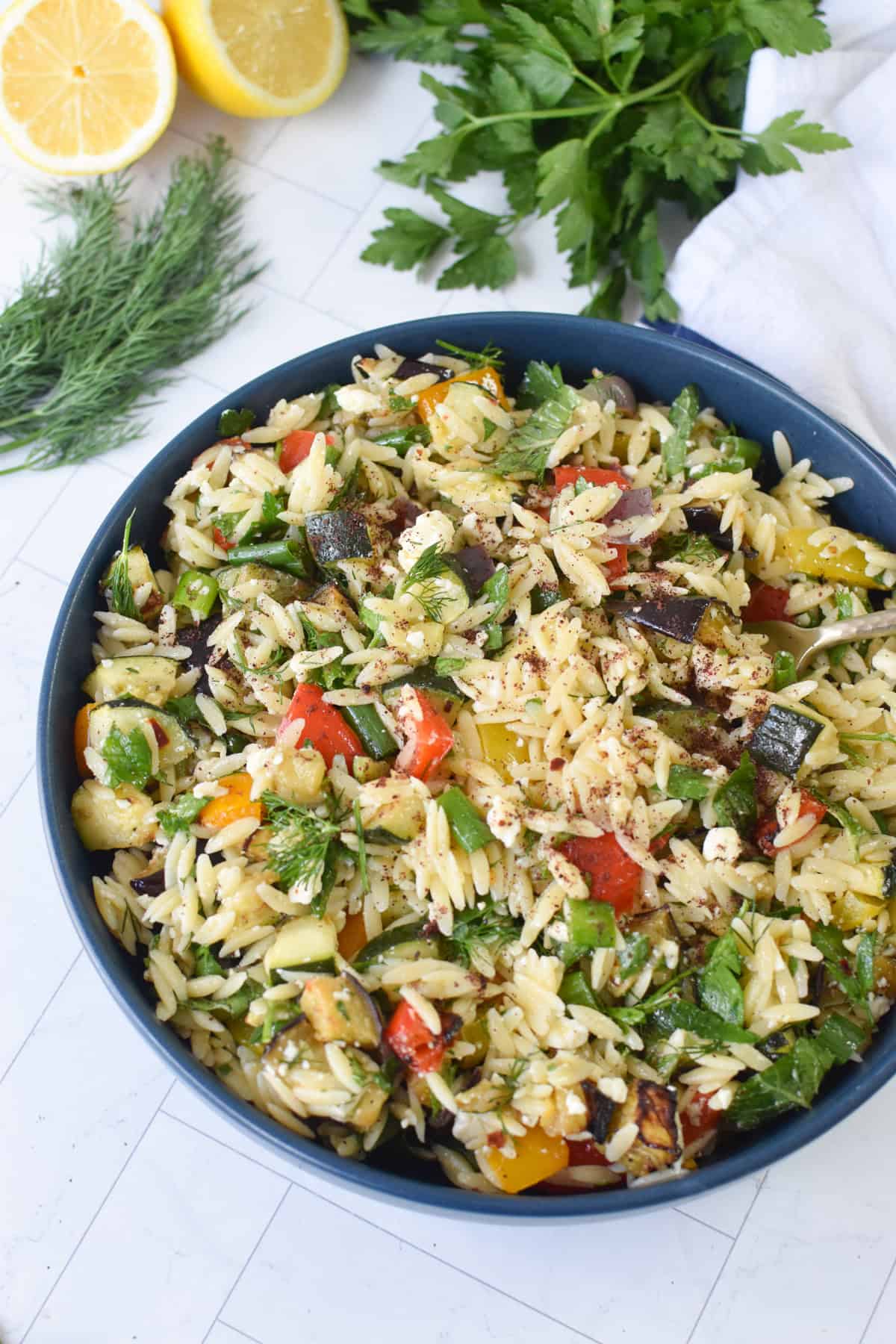 Roasted vegetable orzo salad with feta in a blue bowl