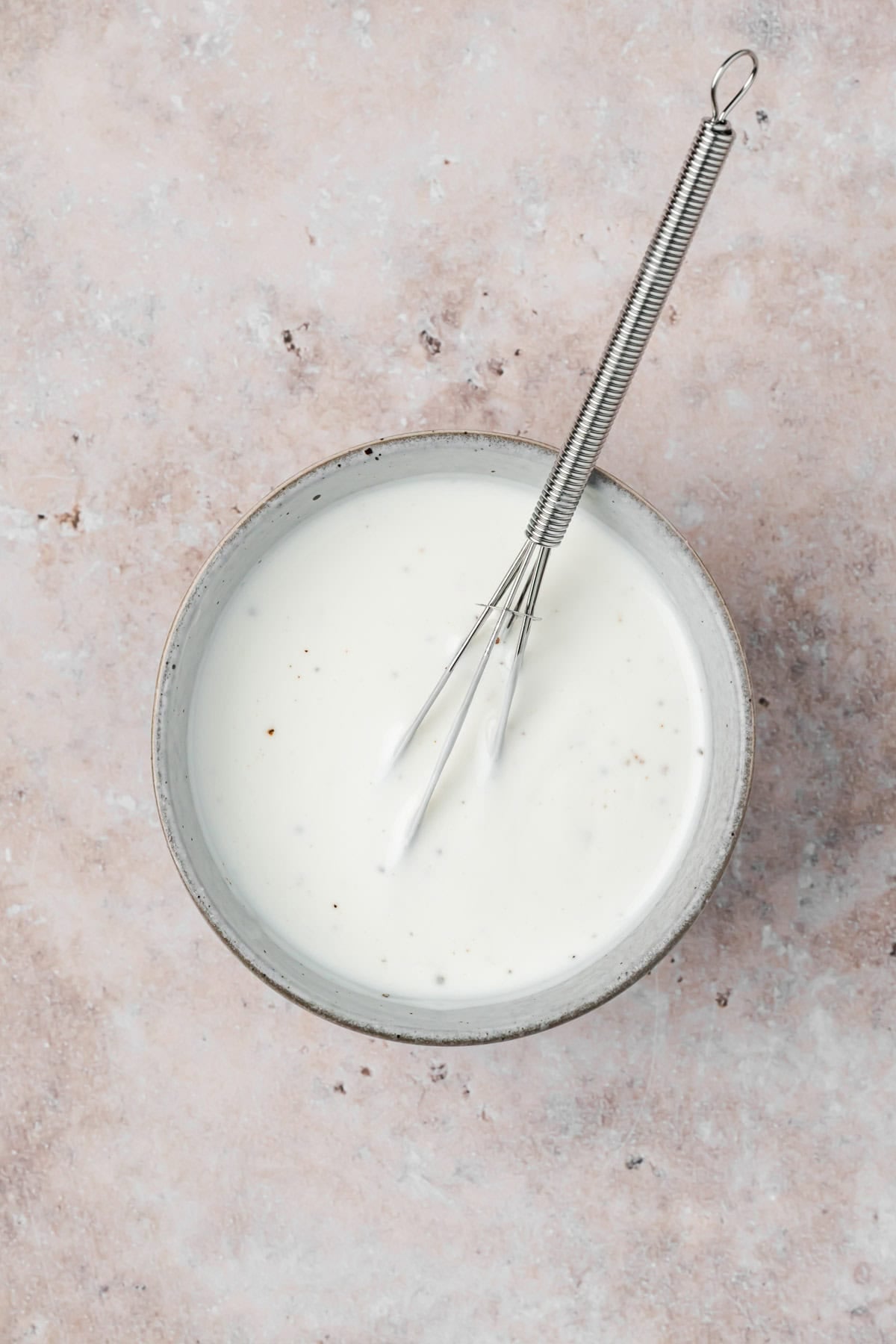 Garlic Yogurt Sauce in bowl with whisk