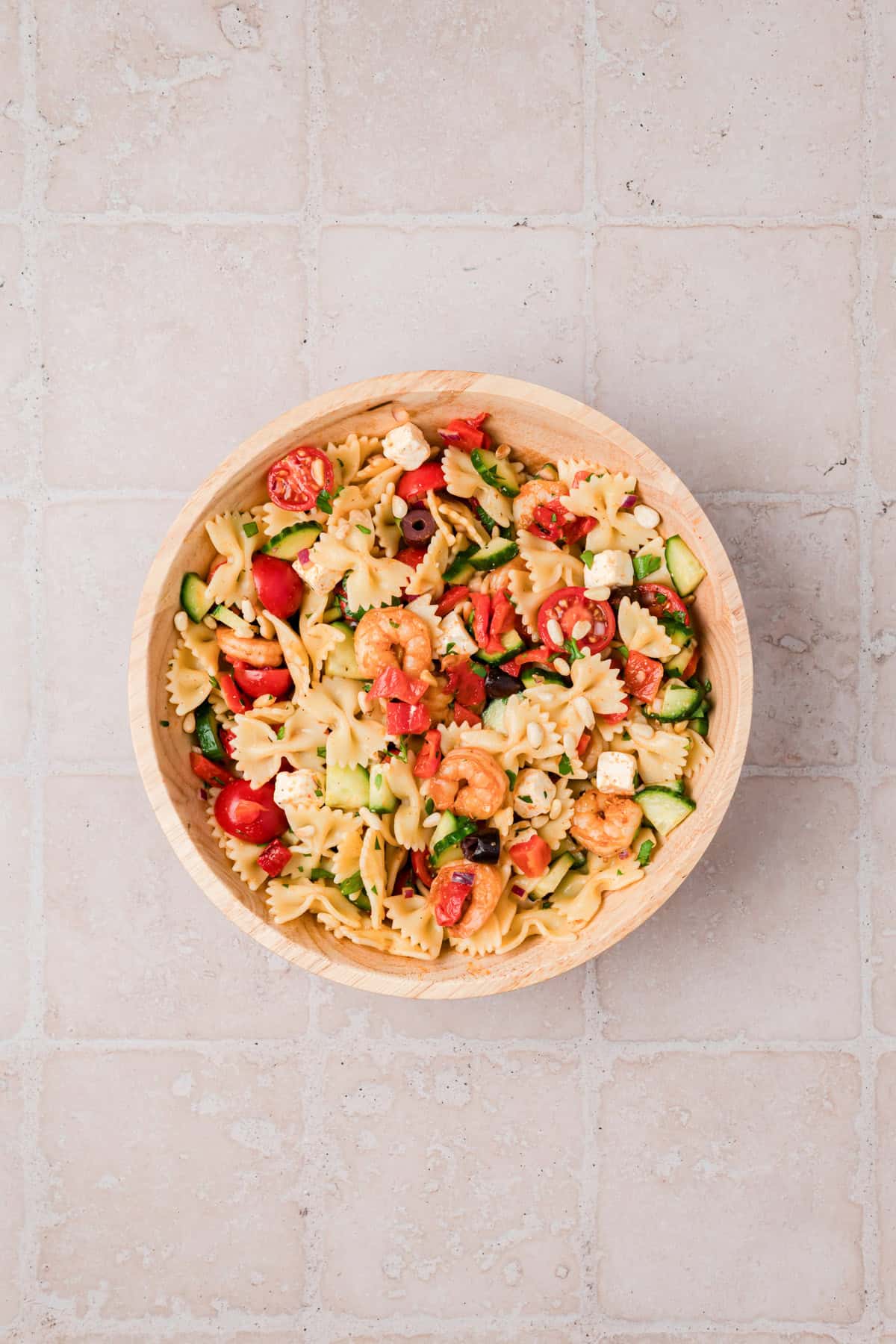 Close up of shrimp pasta salad with toasted pine nuts, Kalamata olives, and feta