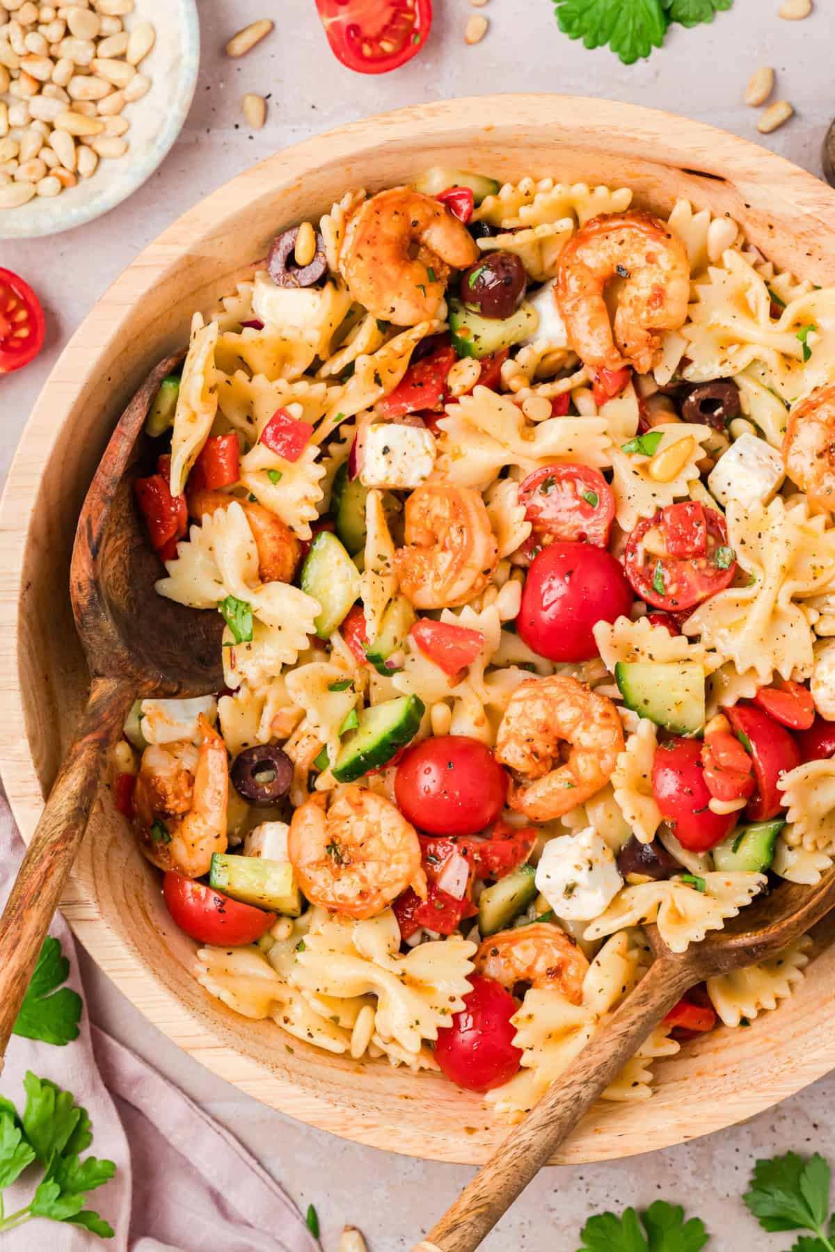 Farfalle pasta salad with seasoned shrimp, cherry tomatoes, cucumber, and feta cheese