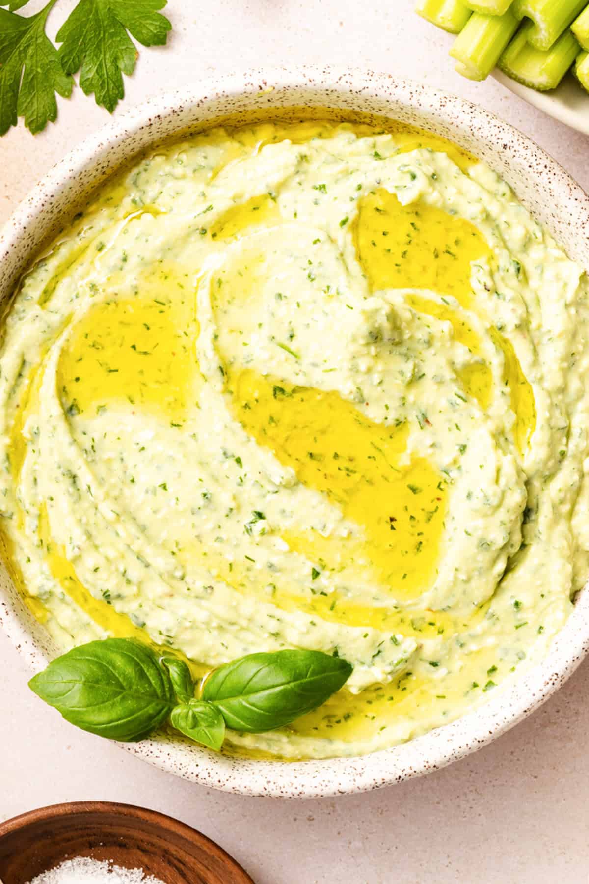 lose up of creamy green goddess dip with feta showing smooth vibrant green texture and olive oil drizzle