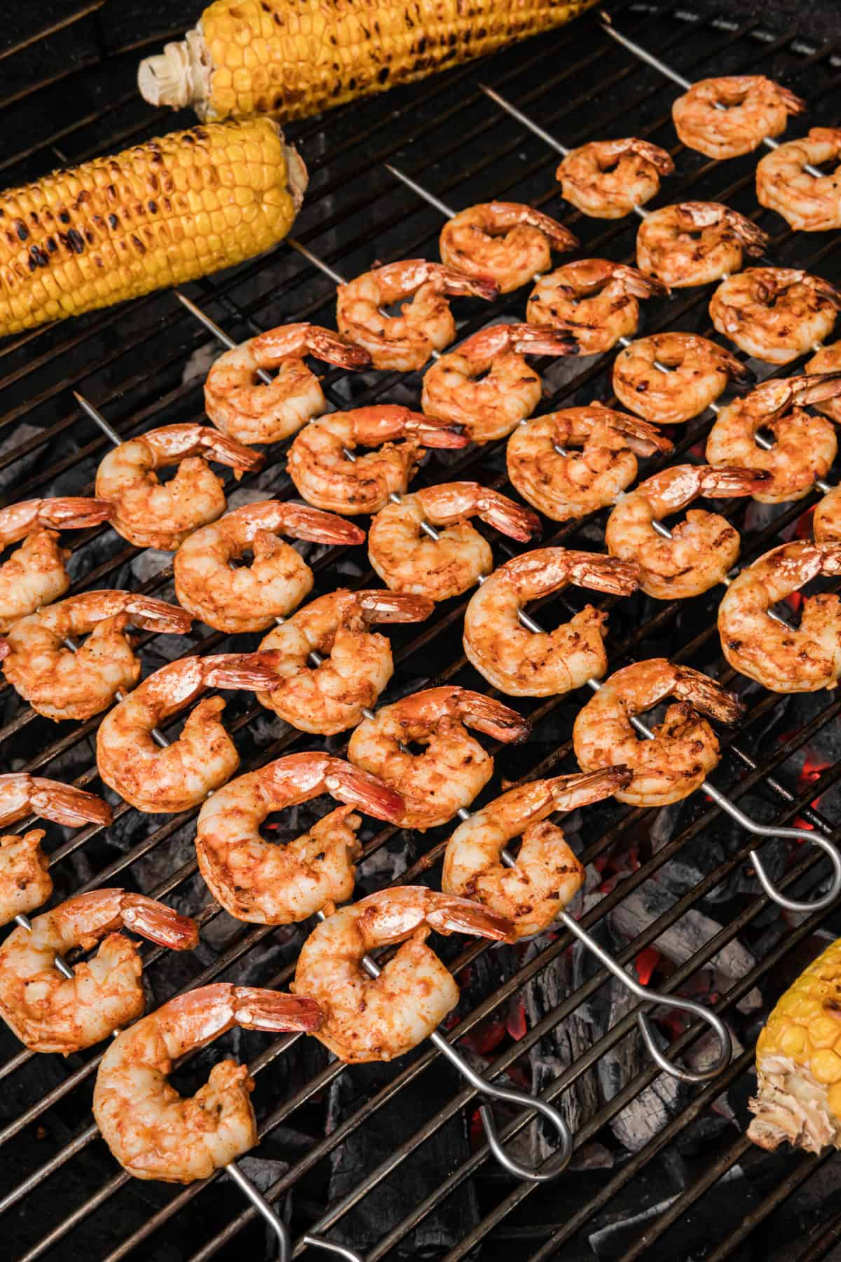 Shrimp grilling next to corn on grill