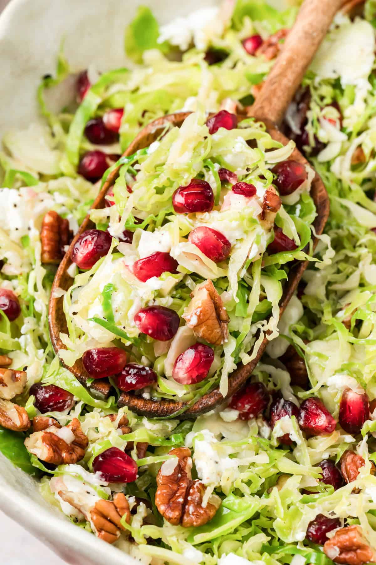 Brussels Spout Salad in a white bowl with a wooden spoon