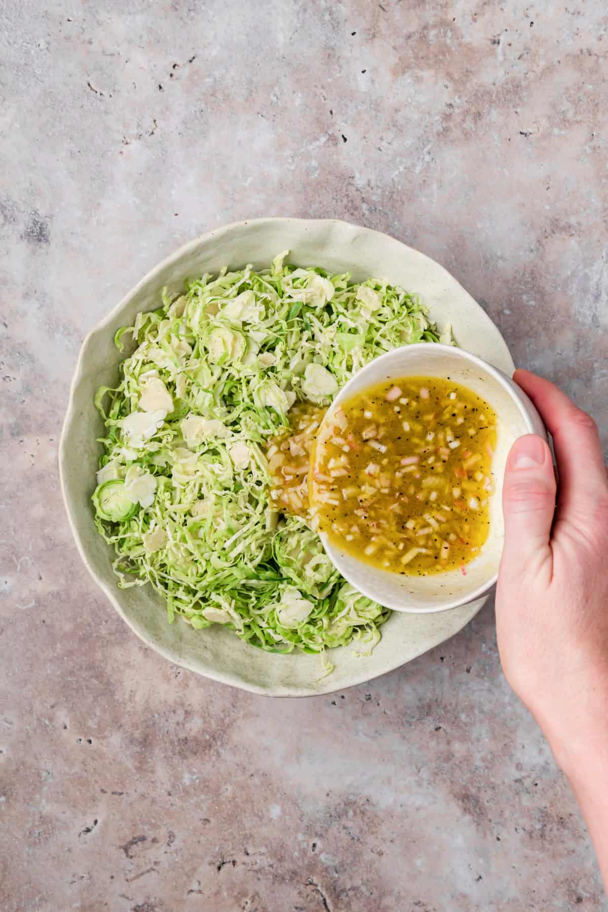 Dressing mixed with brussels sprouts in a bowl