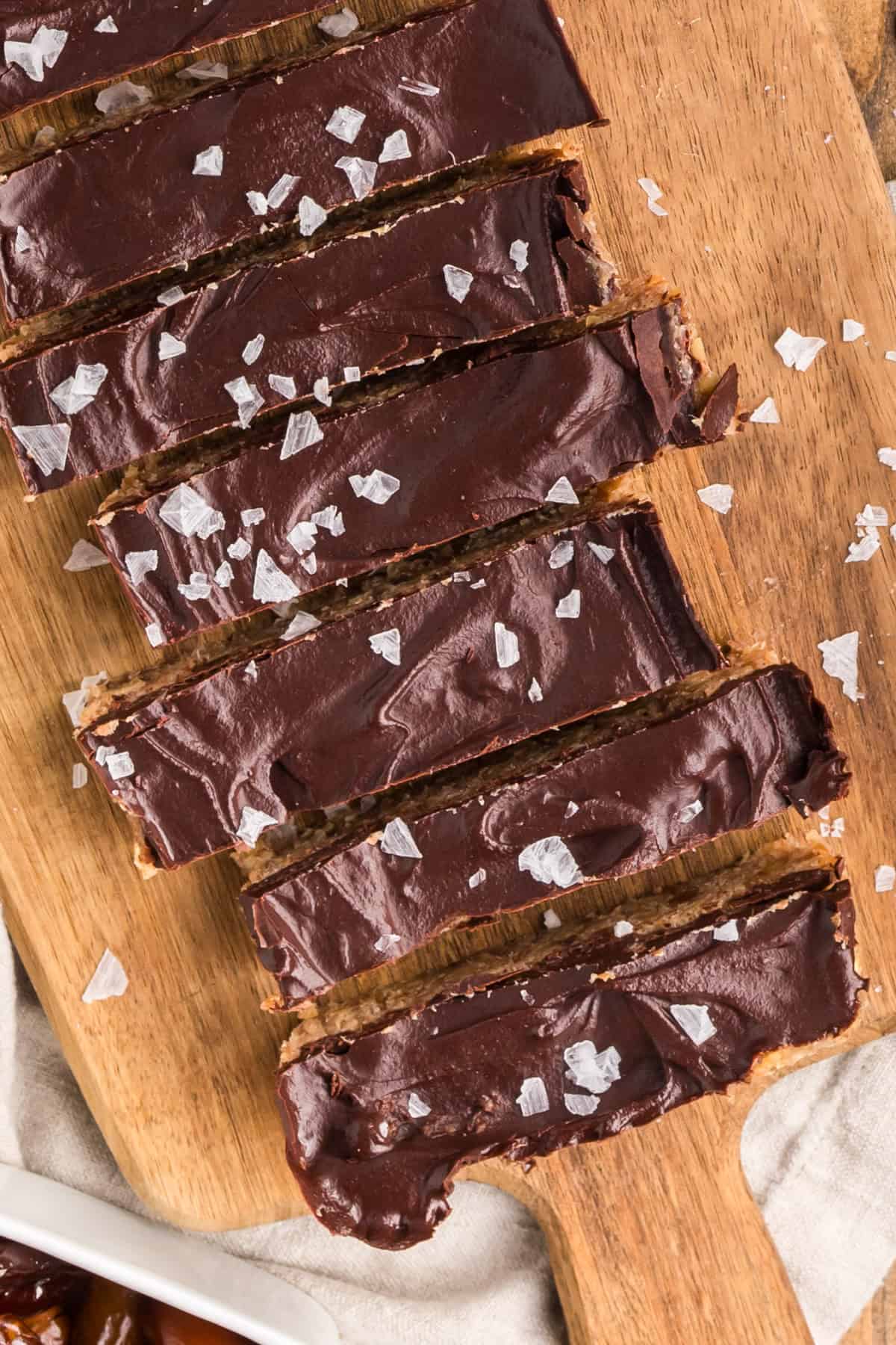 No-bake chocolate walnut date bars sliced on a wooden board